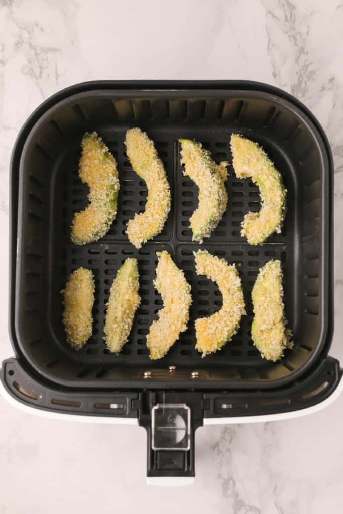 Air Fryer Avocado Fries in air fryer basket about to be cooked