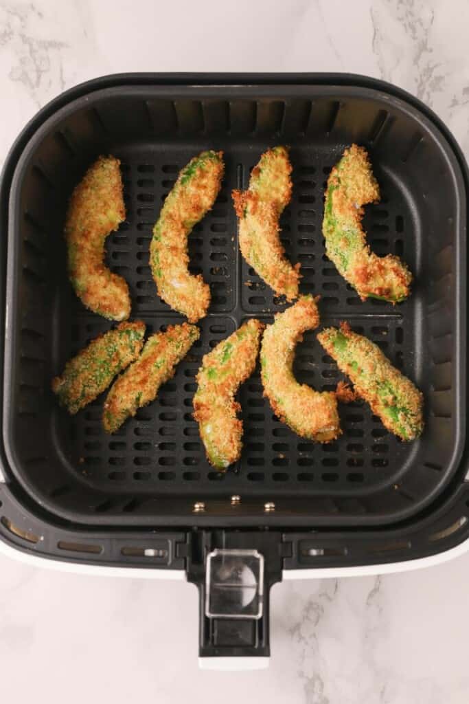 Cooked avocado fries in air fryer basket