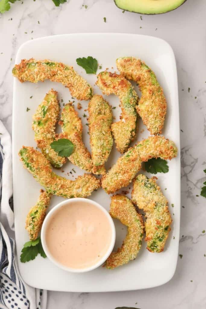 Overhead view of air fryer avocado fries with sriracha ranch dip