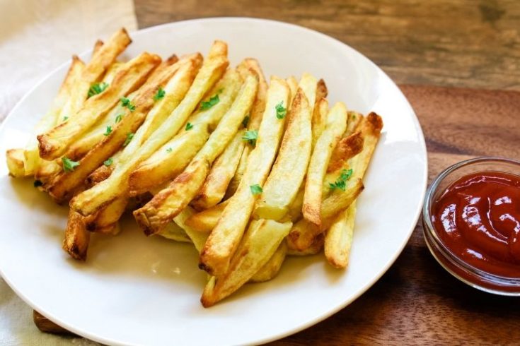 Air Fryer French Fries on white plate with small pinch bowl of ketchup