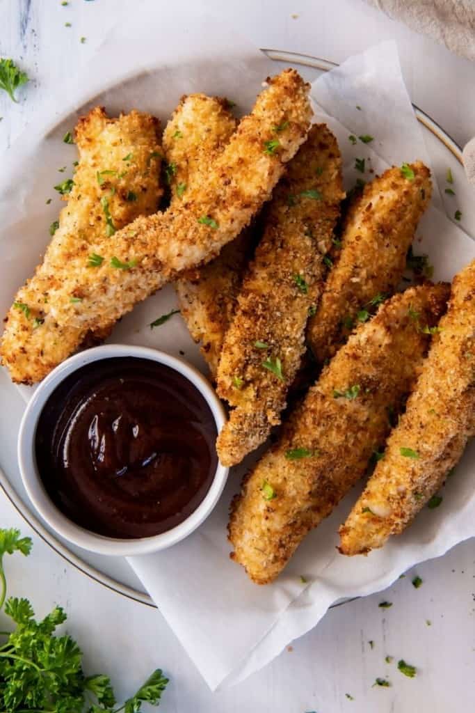 Air Fryer Chicken Fingers served with bbq sauce on a white plate