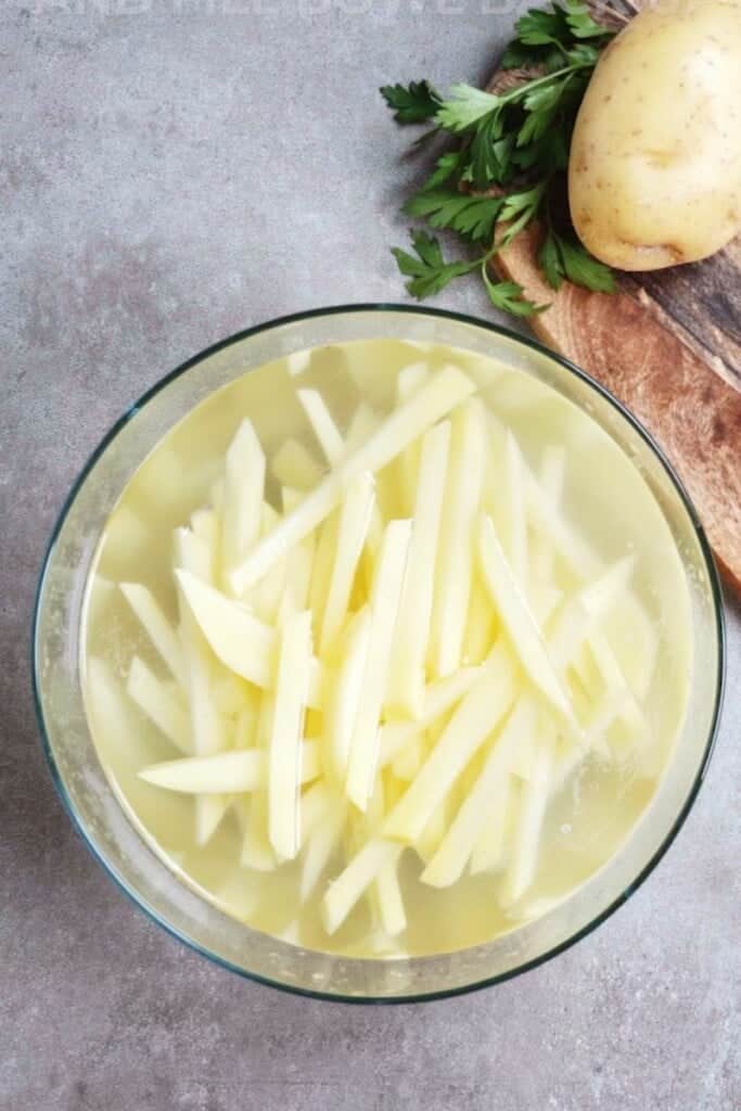 Sliced fries being soaked in water to remove starch