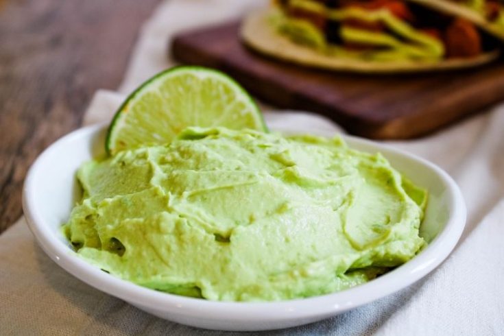 Avocado Lime Crema in white bowl with lime wedge