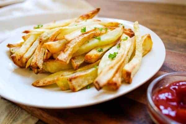 Crispy Air Fryer French Fries on white plate with ketchup on the side