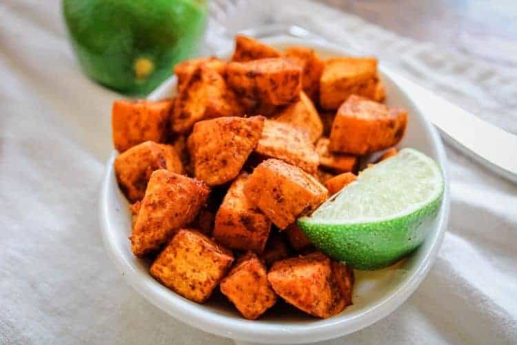 Mexican Sweet Potatoes in a white bowl with a lime slice