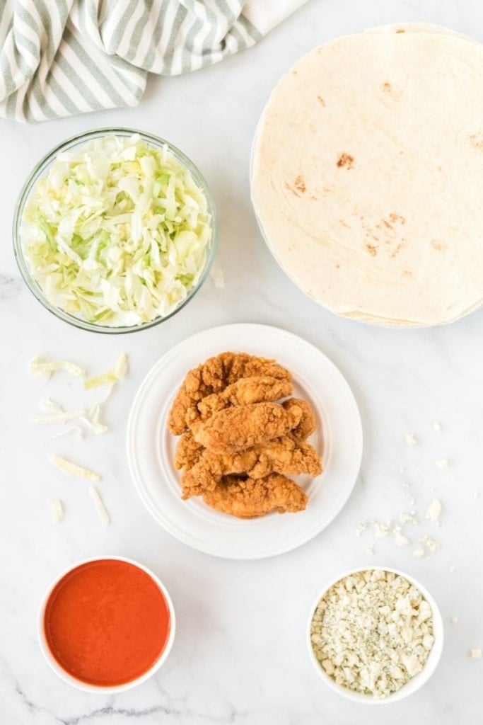 Title and Shown: Spicy and Quick Buffalo Chicken Wrap (open wrap with toppings and completed wrap on white plate)