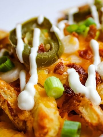 Loaded Bacon Cheese Fries with sour cream drizzled on top