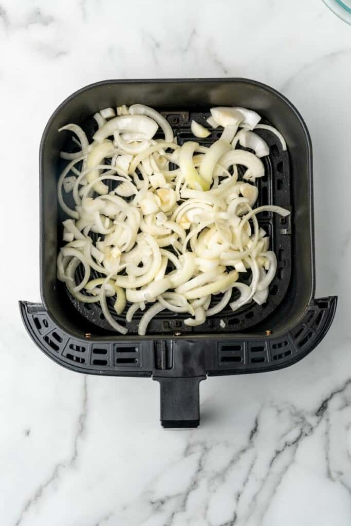 Raw onions in air fryer basket