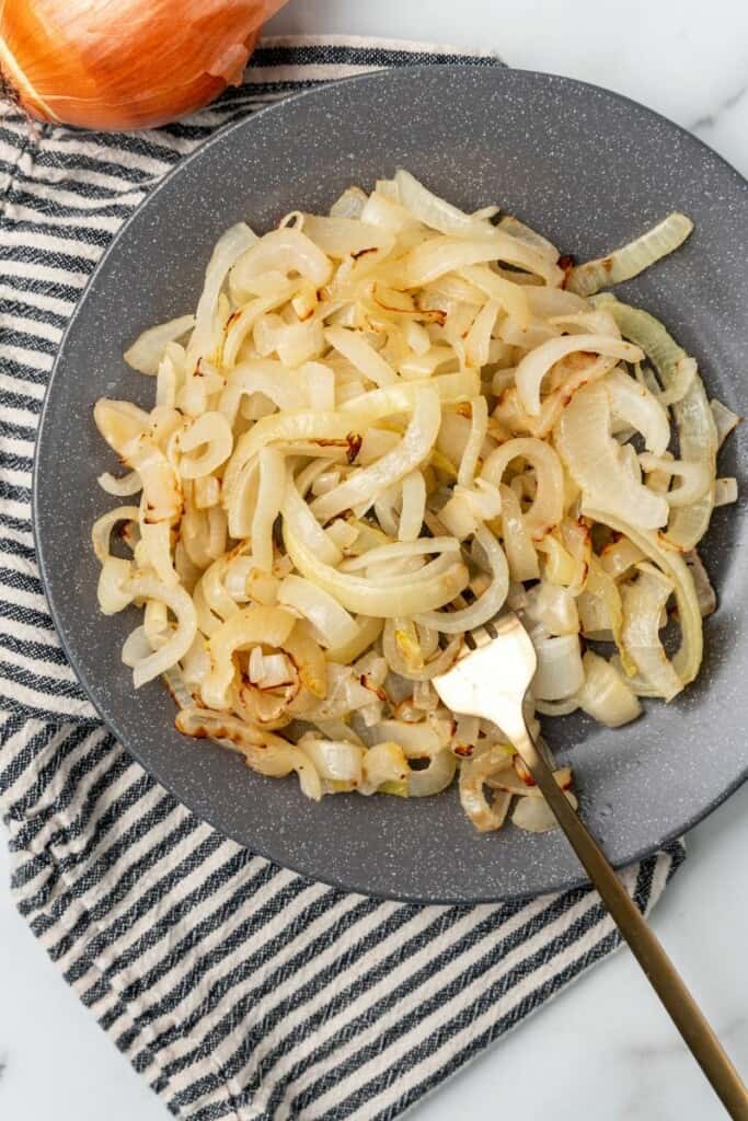 Air Fryer onions on grey plate with a fork in them