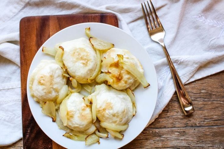 Air Fryer Pierogies with onions on a white plate and fork to side