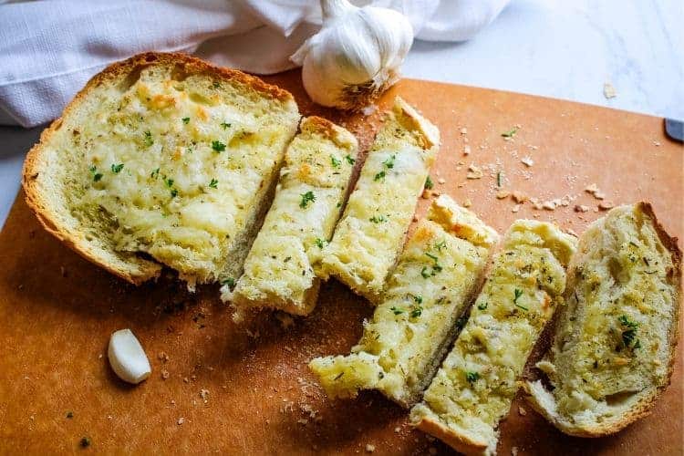 Homemade Garlic Cheese Bread cut into pieces on cutting board