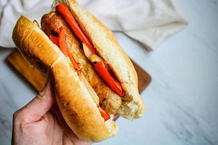 Hand holding Italian Sausage Sandwich
