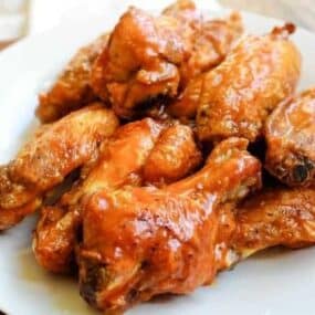 Air Fryer Chicken Wings coated with buffalo sauce on a white plate