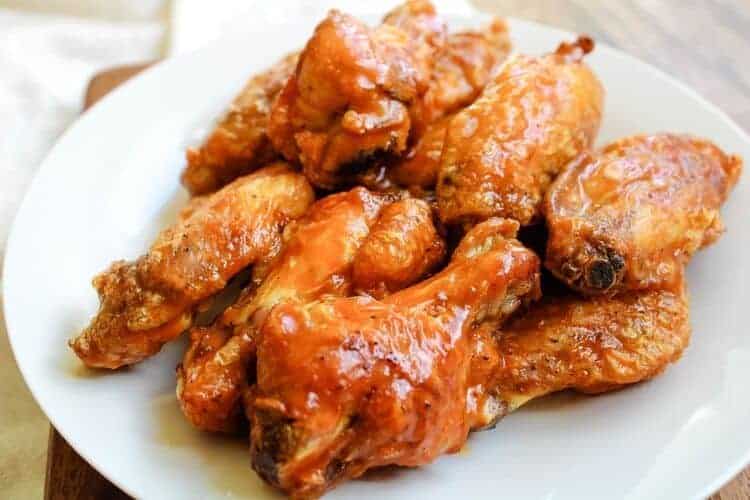 Air Fryer Chicken Wings coated with buffalo sauce on a white plate