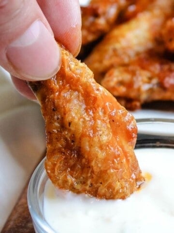 Air Fryer chicken wing being dipped in bowl of blue cheese