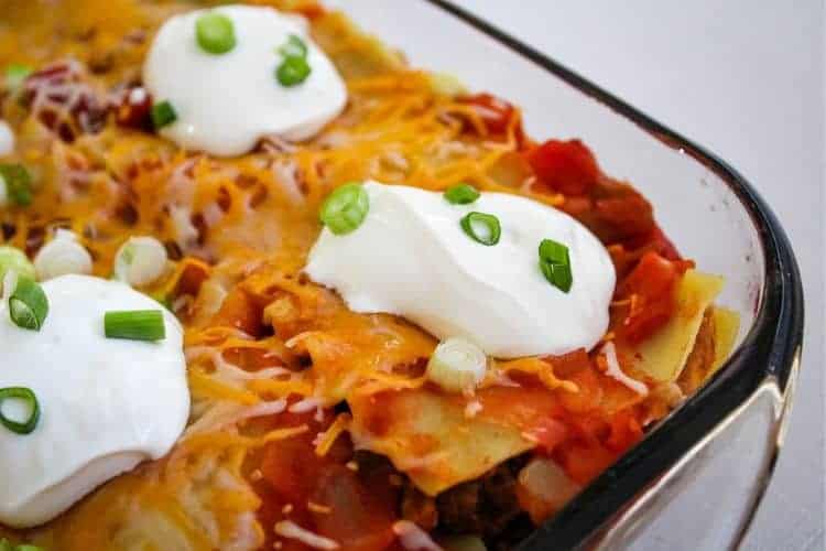 Closeup of Mexican Lasagna with sour cream dollops on top