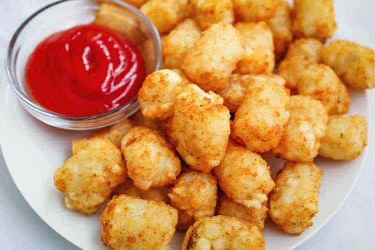 Air Fried Tater Tots on a white plate with ketchup in small clear bowl