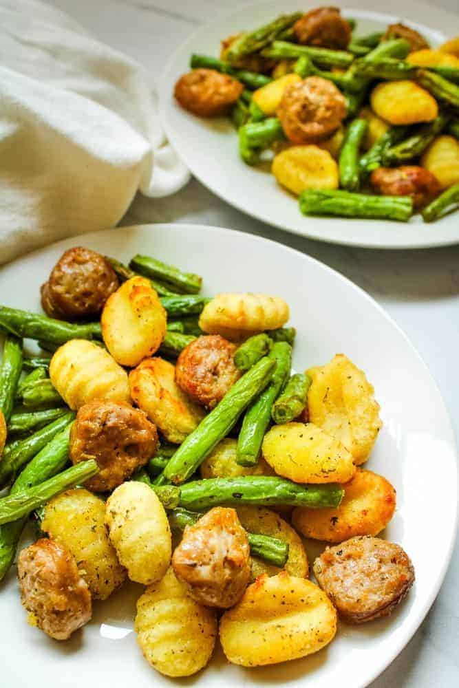 Sausage, Gnocchi, and Green Beans on a white plate