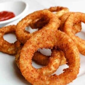 Air Fryer Onion Rings with Ketchup on a white plate