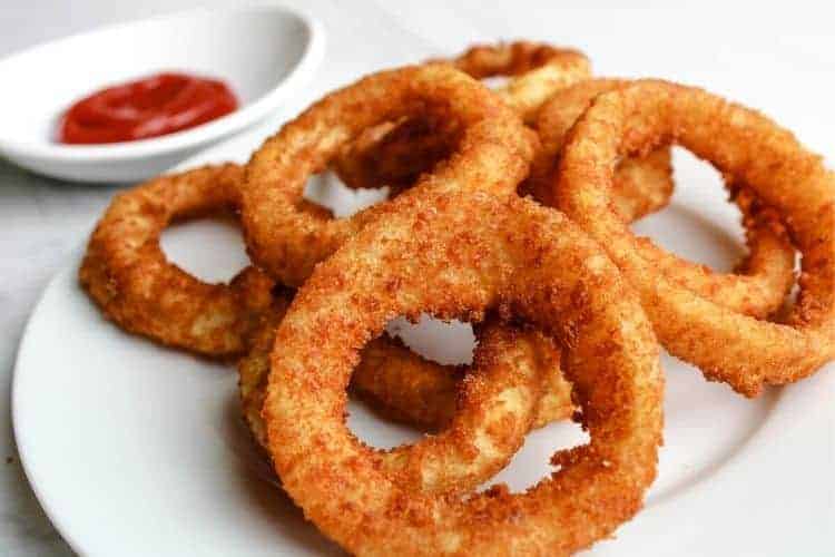 Air Fryer Onion Rings with Ketchup on a white plate