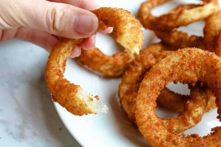 Air Fried Onion Ring in hand bitten into