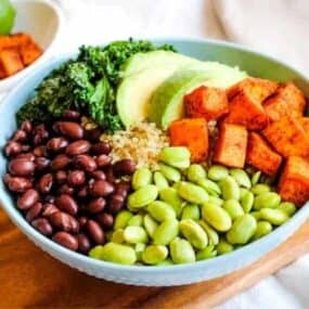Sweet Potato Buddha Bowl in blue bowl with ingredients sectioned in circle