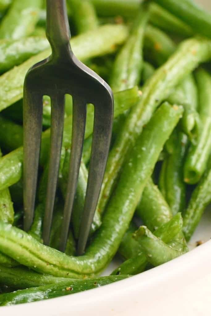 Closeup of air fryer green beans with a fork