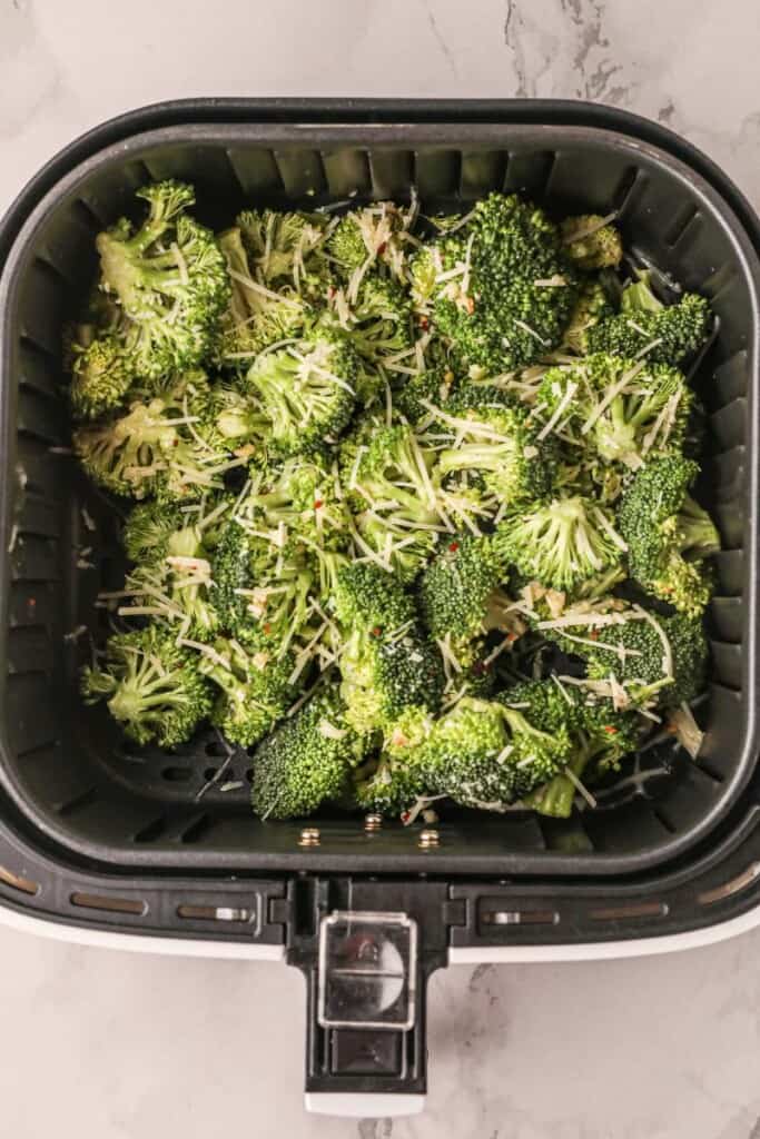 Raw broccoli in air fryer basket