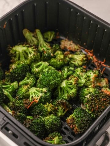 Roasted broccoli in air fryer basket cooked