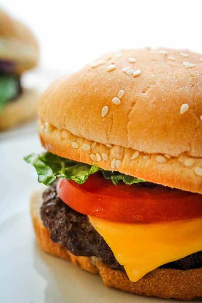 Closeup of Air Fryer Cheeseburger with lettuce and tomato on a sesame bun