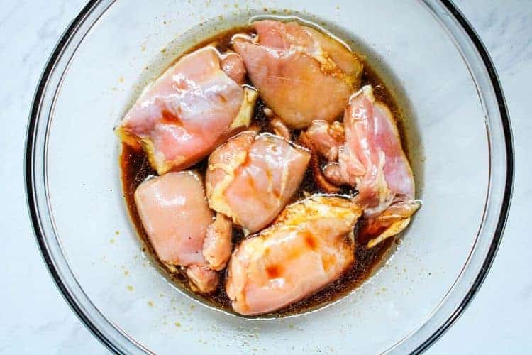 Chicken Thighs Marinated in sauce in a clear bowl