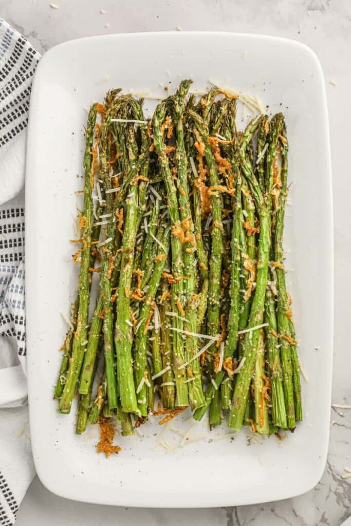 Air Fryer asparagus with cheese on a white plate