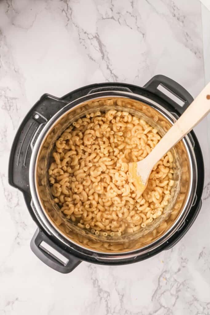Cooked Mac and Cheese in Instant pot with wooden spoon inside