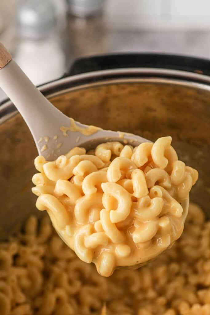 Wooden spoon full of creamy Instant Pot Mac and Cheese