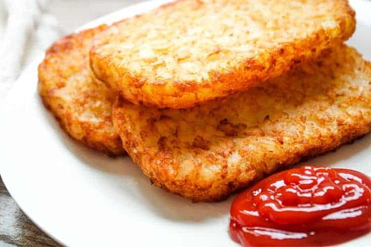 Crispy Hash Brown Patties on a white plate with ketchup