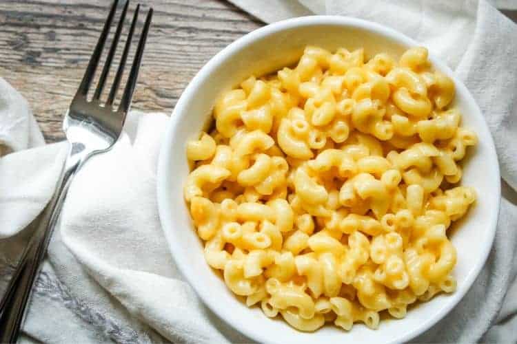 Pressure Cooker Mac and Cheese in a white bowl with fork to the left
