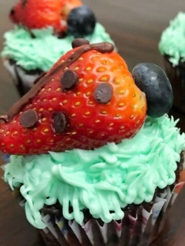 Strawberry Ladybug Cupcakes on a brown table