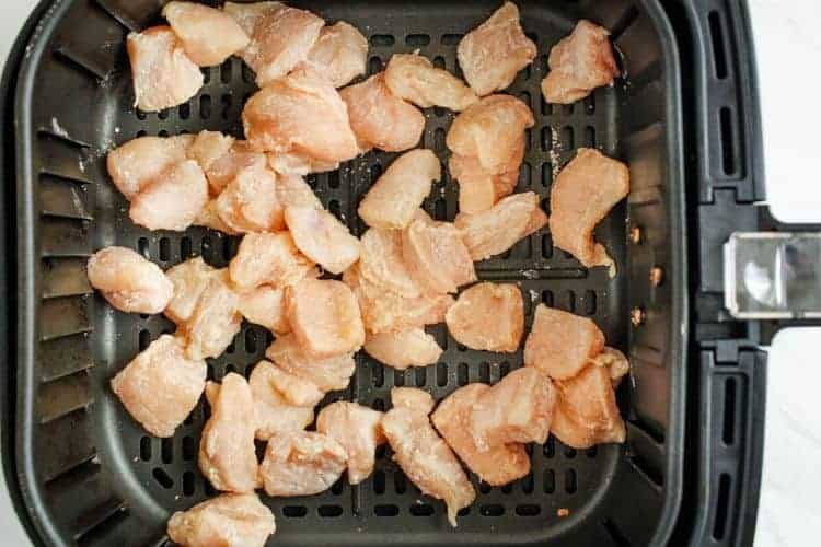 Raw cubed chicken inside air fryer