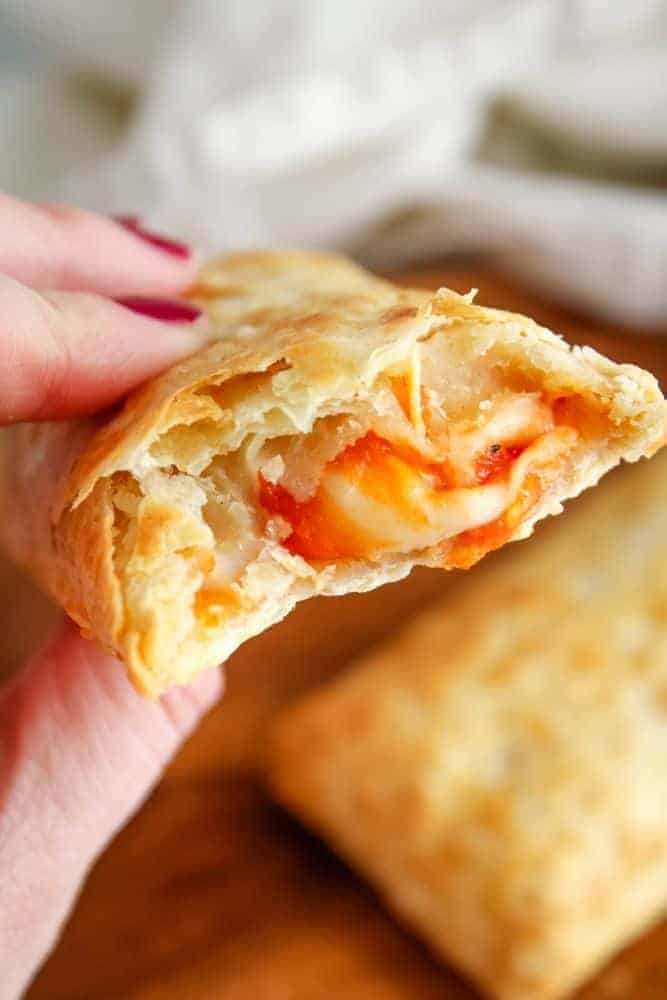 Air Fryer Hot Pocket in hand with cheese oozing out