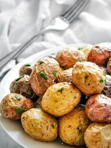 Air Fryer Baby Potatoes on a white plate with a fork in the background