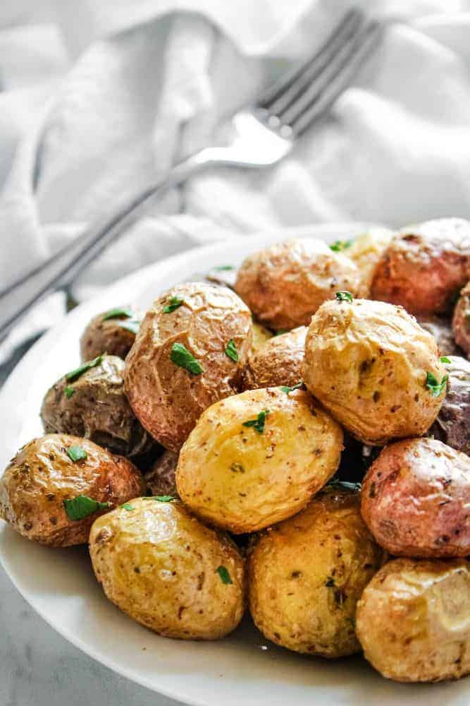 Air Fryer Baby Potatoes on a white plate with fork in the background