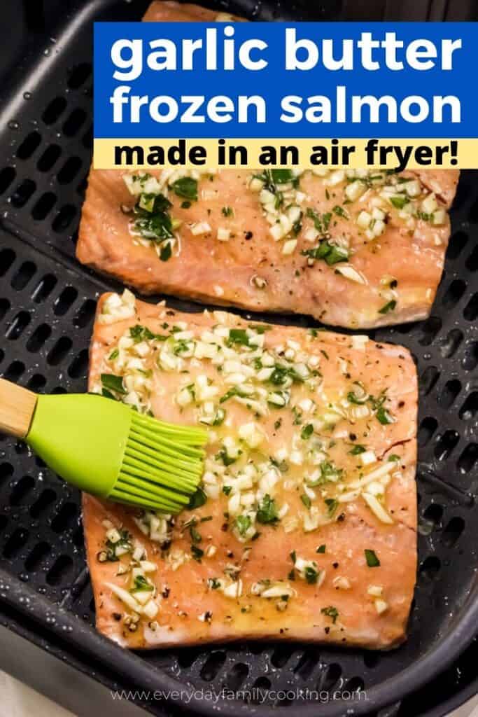 Title and shown: Garlic Butter frozen salmon made in the air fryer (shown inside the air fryer with a basting brush)
