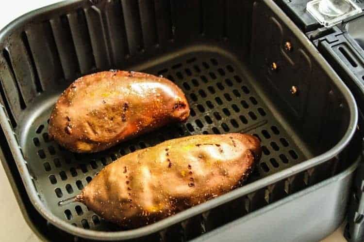 2 cooked sweet potatoes inside air fryer