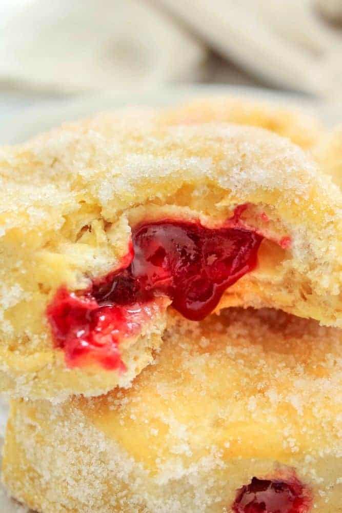 Air Fryer Jelly Donuts Stacked bite taken out and jelly oozing out