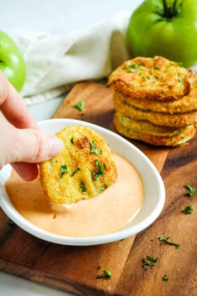 Dipping a fried green tomato into sriracha mayo sauce