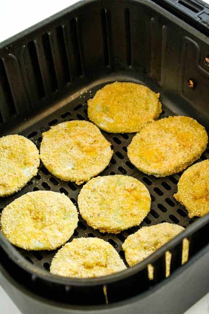 Breaded green tomato slices inside air fryer