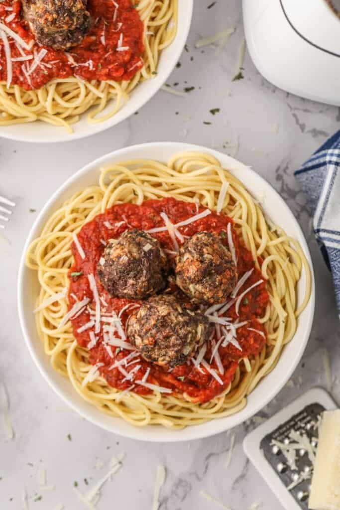 Air fryer meatballs on spaghetti and sauce on a plate