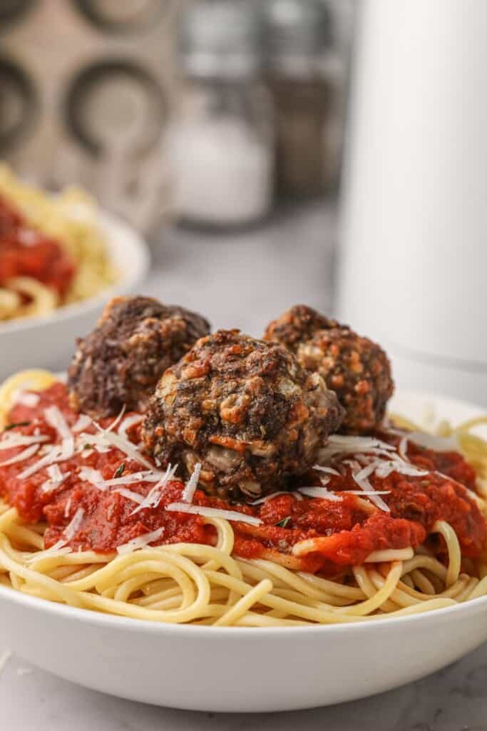 Closeup of air fryer meatballs on spaghetti and sauce on a plate
