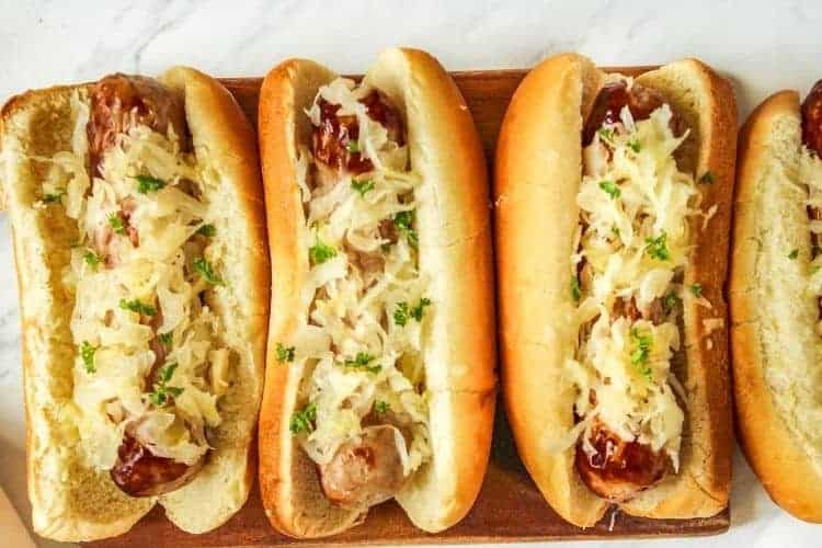 Air Fryer Bratwurst in a row in buns with sauerkraut on top