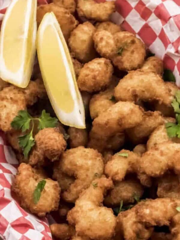 Air Fryer Popcorn Shrimp in a red basket with lemon wedges